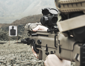 Person aiming firearm at target